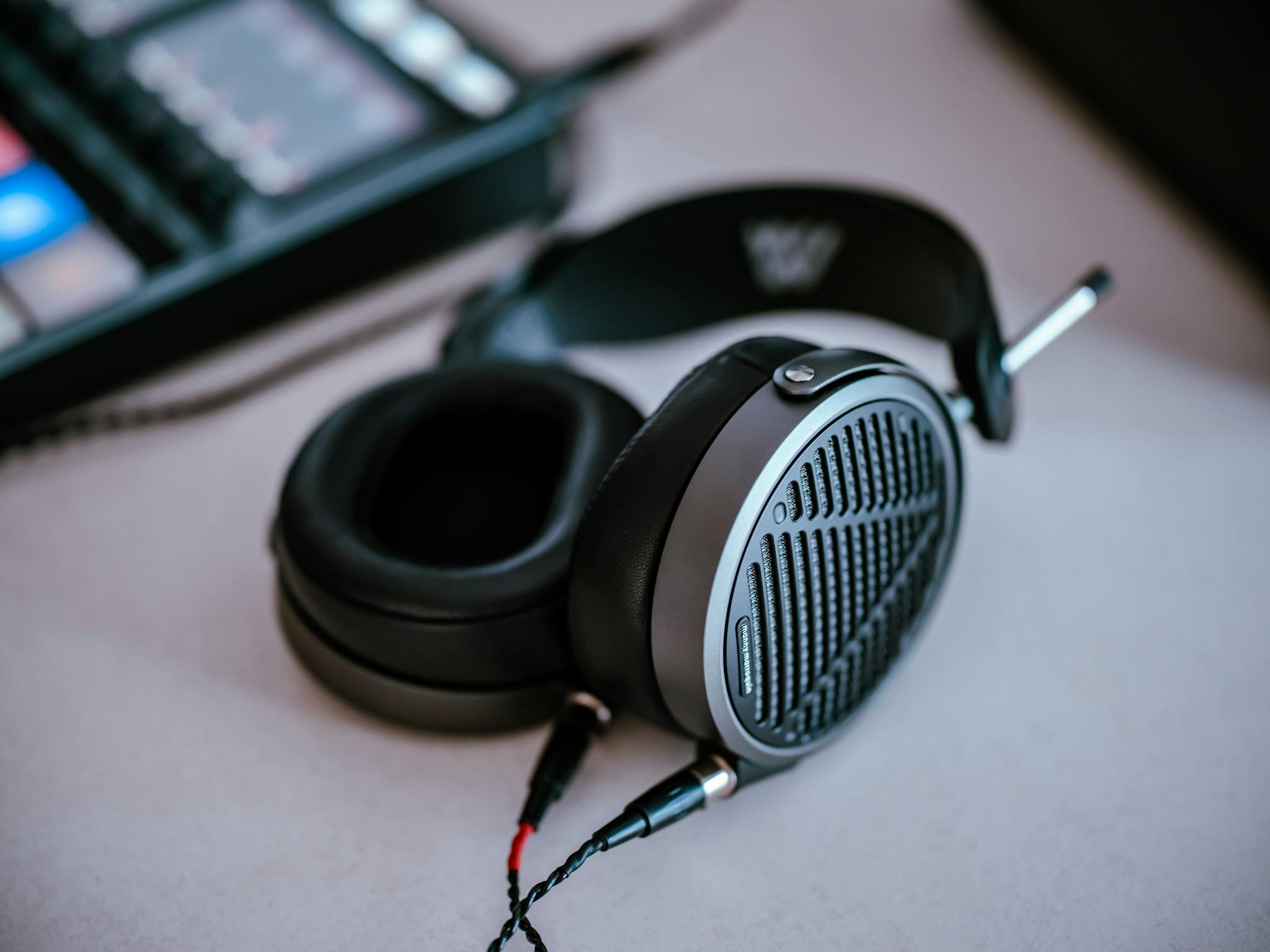 Close-up of high-end headphones on a desk, showcasing sleek design and premium build.